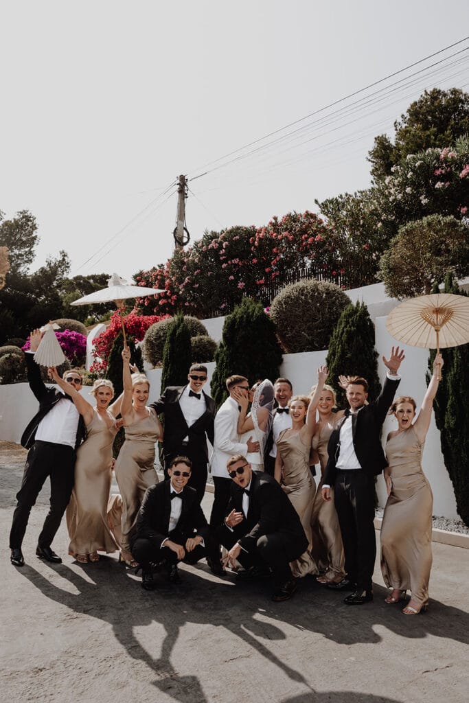 Bridal party celebrating joyfully outdoors during a chic wedding in Ibiza, Spain
