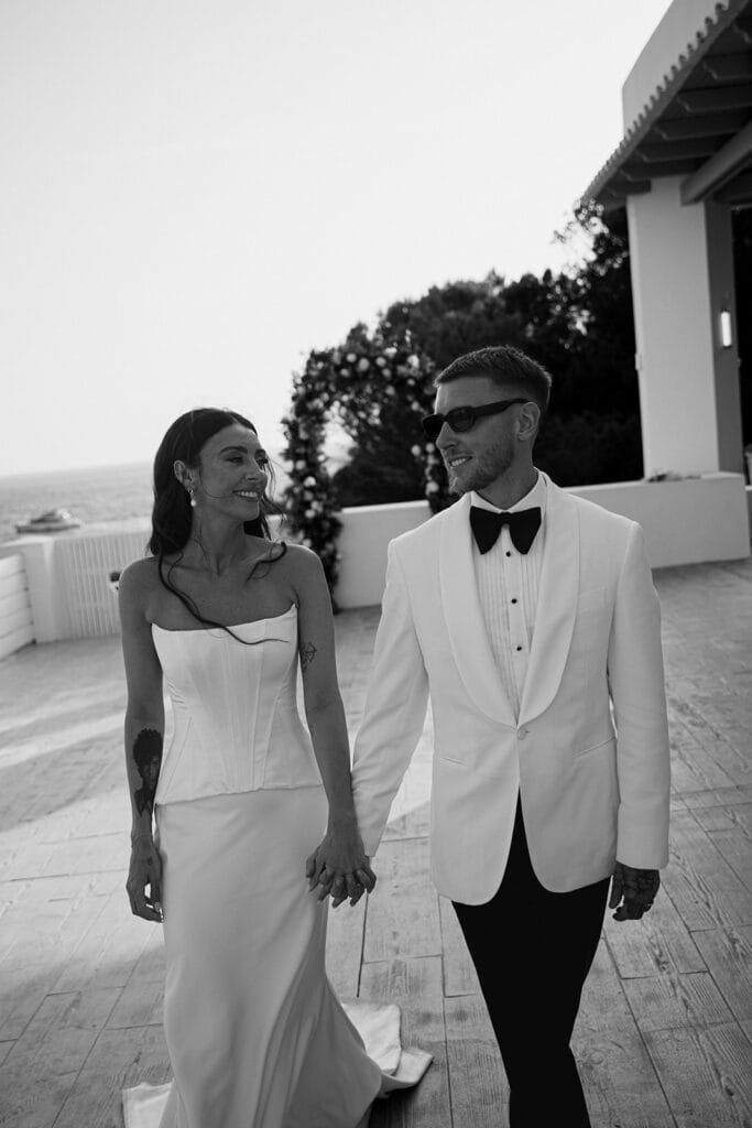 Bride and groom holding hands and smiling after their wedding ceremony in Ibiza, Spain
